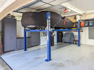 Two Car garage with car lift, extra width and depth.  Storage alongside walls and overhead.