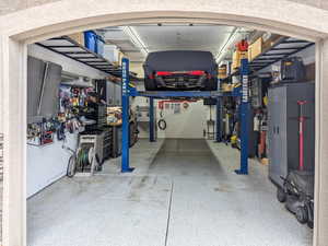 Single car garage with car lift, extra width and depth. Storage alongside walls and overhead.