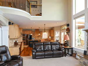 Living room featuring baseboards, dark carpet, a towering ceiling, and recessed lighting