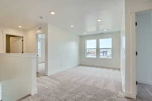 Unfurnished room featuring baseboards, light colored carpet, and recessed lighting