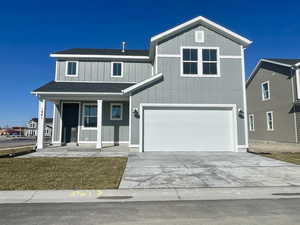 View of front of property featuring concrete driveway, roof with shingles, a porch, and an attached garage