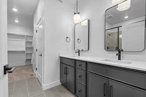 Full bath with a sink, a shower stall, double vanity, and visible vents