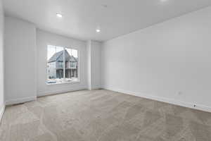 Unfurnished room with recessed lighting, baseboards, light colored carpet, and visible vents