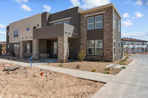 View of front of home featuring stucco siding and stone siding