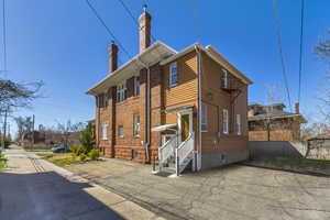 Alley way view towards home - View of front of home featuring entry steps, fence, and a chimney