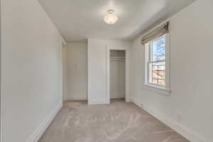 Unit 5 - North Facing - Unfurnished bedroom with a closet, baseboards, and light colored carpet.
