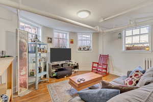 Unit 1 - Living area with light wood finished floors, baseboards, and radiator heating unit