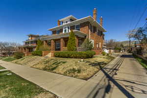 Traditional style home with brick siding, a front lawn, and a chimney