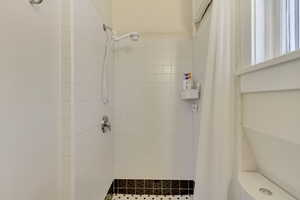 Unit 6 - Full bathroom featuring tiled shower