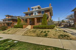 Traditional style home featuring brick siding, a porch, and a chimney