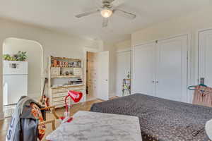 Unit 6 - Bedroom with light wood-type flooring, a ceiling fan, and freestanding refrigerator