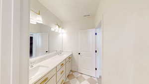 Bathroom featuring double vanity, a sink, visible vents, and a textured ceiling