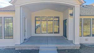 Property entrance featuring a shingled roof