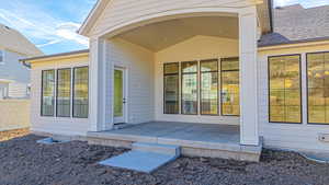 View of exterior entry with a patio