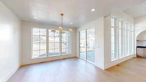 Unfurnished dining area featuring plenty of natural light and wood finished floors