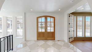 Entryway with baseboards, a textured ceiling, french doors, and recessed lighting