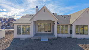 Back of house with a shingled roof