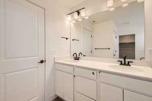 Primary bathroom featuring double vanity, separate tub and shower