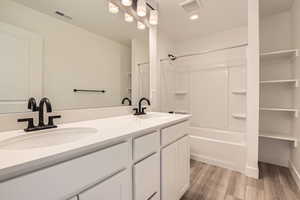 Secondary bathroom featuring double vanity, and storage shelves