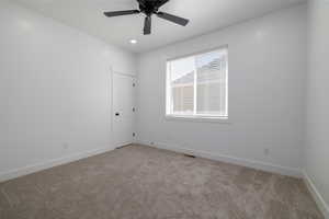 Empty room with light colored carpet, baseboards, and ceiling fan