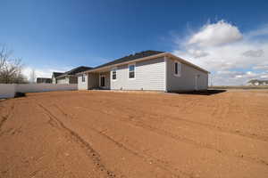 Rear view of property featuring fence