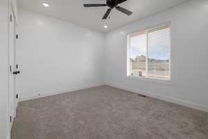 Carpeted empty room featuring ceiling fan, recessed lighting, and baseboards