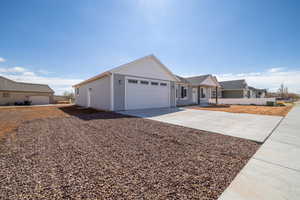 Ranch-style house featuring concrete driveway and an attached garage