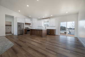 Kitchen featuring open floor plan, dark wood-style floors, and appliances with stainless steel finishes