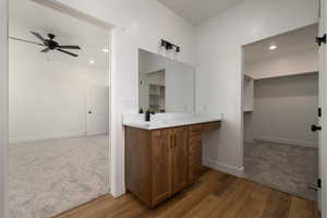 Bathroom with vanity, a ceiling fan, recessed lighting, hardwood / wood-style floors, and baseboards