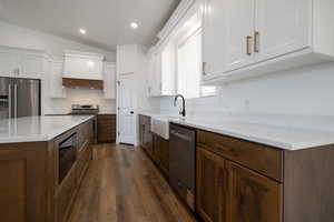 Kitchen with a sink, dark wood finished floors, white cabinetry, and stainless steel appliances