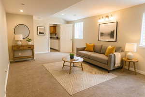 Living area featuring vaulted ceiling, baseboards, light colored carpet, and recessed lighting