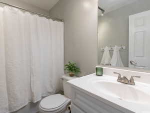 Bathroom featuring vanity, toilet, and shower / tub combo with curtain