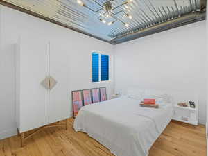 Bedroom featuring hardwood / wood-style floors and a chandelier