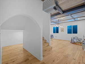 Interior space featuring arched walkways, hardwood / wood-style flooring, and baseboards