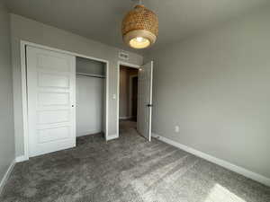 Unfurnished bedroom featuring baseboards, visible vents, and carpet