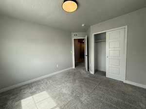 Unfurnished bedroom featuring baseboards, visible vents, a closet, and a textured ceiling