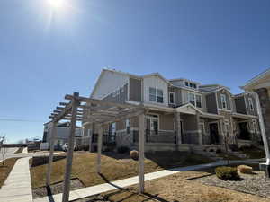 View of property exterior featuring stone siding, board and batten siding, and a pergola