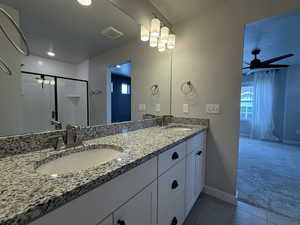 Bathroom featuring a stall shower, visible vents, tile patterned flooring, and a sink