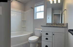 Bathroom with tile patterned flooring, vanity, toilet, baseboards, and shower / tub combination
