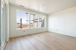 Spare room with visible vents and wood finished floors