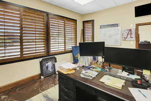 Office featuring a drop ceiling and baseboards