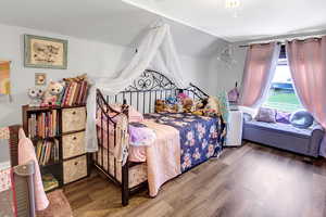 Bedroom featuring vaulted ceiling and wood finished floors