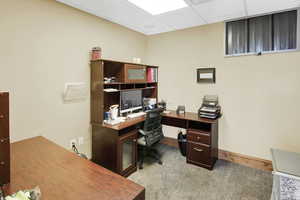 Carpeted office featuring baseboards and a drop ceiling