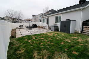 View of yard with a fenced backyard, entry steps, and a patio area