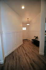 Unfurnished room featuring a wainscoted wall and dark wood-type flooring