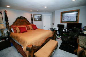 Carpeted bedroom featuring a textured ceiling and recessed lighting