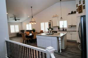 Kitchen with white cabinetry, a sink, ceiling fan with notable chandelier, and freestanding refrigerator