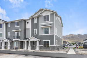 Townhome / multi-family property featuring stone siding, board and batten siding, central AC unit, and a mountain view