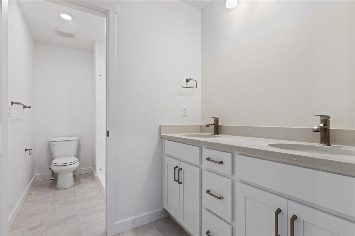 Full bathroom featuring visible vents, toilet, tile patterned flooring, and a sink