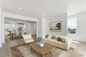 Living area with baseboards, light wood-type flooring, and recessed lighting